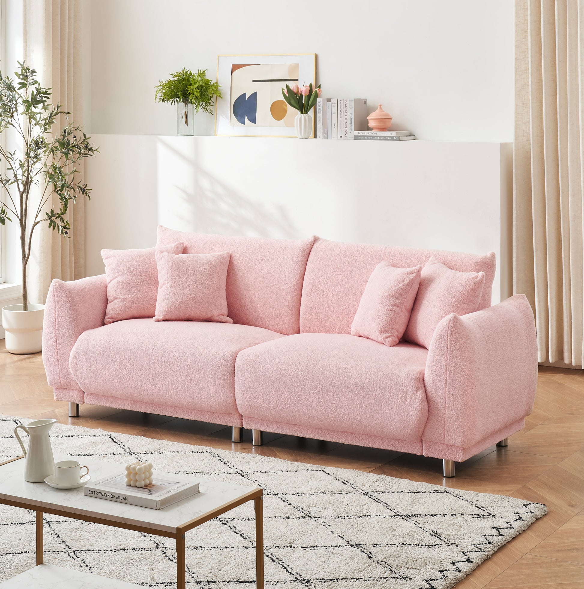 The 86.6 inch teddy fleece pink sofa with four throw pillows and hardware feet can sit comfortably in an apartment bedroom without taking up space