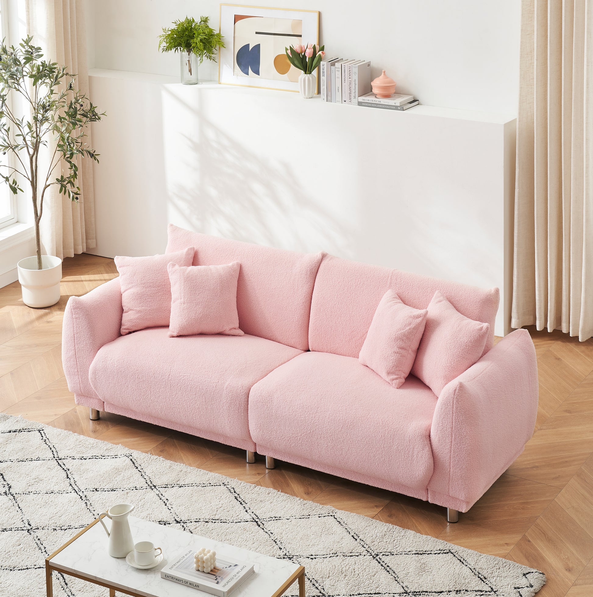 The 86.6 inch teddy fleece pink sofa with four throw pillows and hardware feet can sit comfortably in an apartment bedroom without taking up space